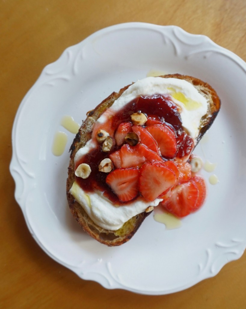 Ricotta toast with strawberry jam and macerated fresh strawberries on top